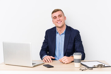Young business man with a laptop looks aside smiling, cheerful and pleasant.