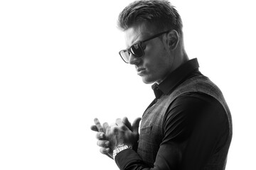 Black and white portrait of beautyful guy on white background. High fashion model posing in studio. Attractive man in classic suit and sunglasses.