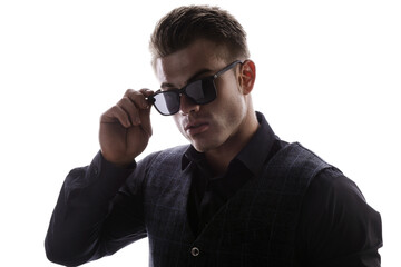 Portrait of beautyful guy on white background. High fashion model posing in studio. Attractive man in classic suit and sunglasses.