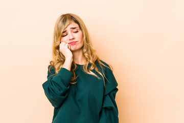 Young blonde caucasian woman who feels sad and pensive, looking at copy space.