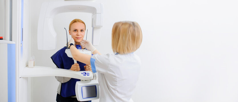 A dental x-ray doctor is making to a young female patient a digital dental x-ray panoramic radiography orthopantomography  of the oral cavity.