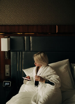 young woman with cell phone on the bed