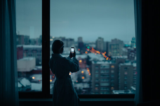 young woman near the window with cell phone