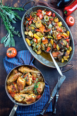Traditional French lemon chicken with vegetable ratatoulle offered as top view in a rustic casserole