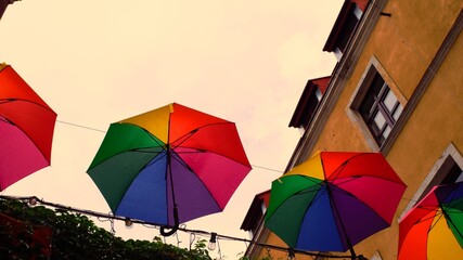 Fototapeta na wymiar Umbrellas in rainbow colors above the street.