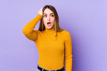 Young caucasian woman isolated on purple background being shocked, she has remembered important...