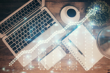 Financial market graph and top view computer on the desktop background. Double exposure. Investment concept.