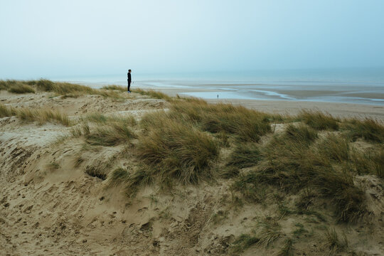 Boy gazes over the horizon at Camber Sands