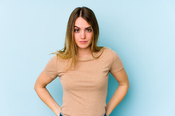 Young caucasian woman isolated on blue background sad, serious face, feeling miserable and displeased.