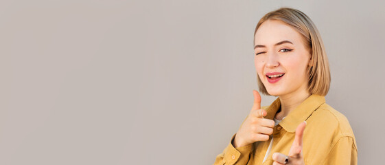 Smiling happy woman pointing at the camera with both hands and her head tilted to the side with a...