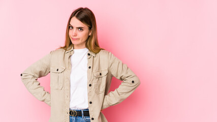 Young caucasian woman isolated on pink background confused, feels doubtful and unsure.