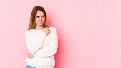 Young caucasian woman isolated on pink background confused, feels doubtful and unsure.