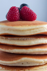 Fluffy pancake stack with raspberries and  blueberries