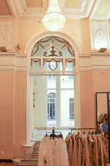 Tenderly pink walls in an antique clothing store in St. Petersburg. Pink dresses hang on hangers