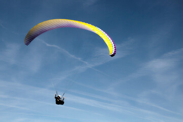 Man flying in the sky with a paraglide in a blue day