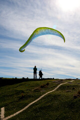 man learning to control the paraglide with friends