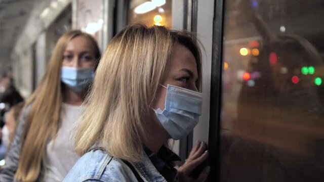 Health-conscious females wearing protective face masks while riding in subway train during epidemic of 2019-ncov. Sane women in underground metro, lockdown, social distancing in public transport