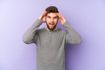 Young caucasian man isolated on purple background receiving a pleasant surprise, excited and...