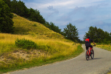 Naklejka premium Man mountain biking along a road