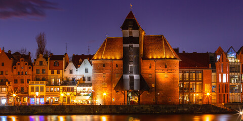 Old harbour crane and city gate Zuraw in old town of Gdansk at night, Poland