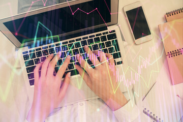 Double exposure of woman hands working on computer and forex chart hologram drawing. Top View. Financial analysis concept.