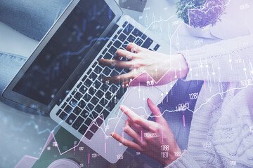 Double exposure of woman hands working on computer and forex chart hologram drawing. Top View. Financial analysis concept.