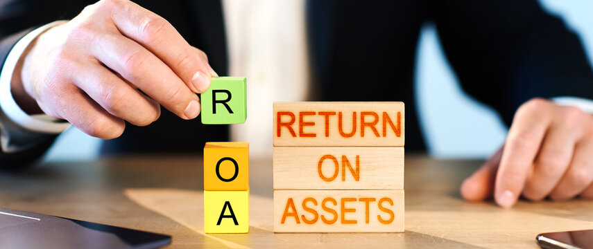 roa concept. a man puts wooden blocks in the inscription return on assets