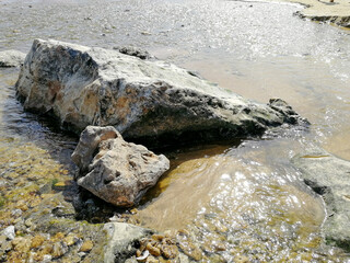 Close shot of two rocks surrounded by a stream