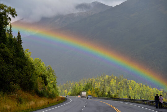 Tourists stop to take pictures of a rainbow over Alaska's Seward Highway.
