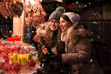 Female friends choose sweets on Christmas market