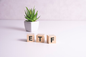 ETF concept on wooden cubes in a pot in the background.