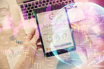 Double exposure of man's hands holding and using a digital device and forex graph drawing. Financial market concept.