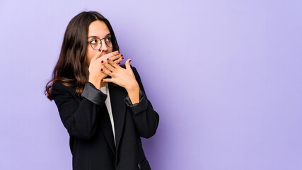 Young mixed race hispanic woman isolated thoughtful looking to a copy space covering mouth with hand.