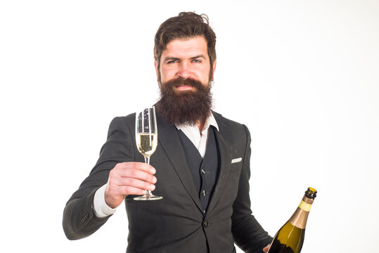 Attractive man in suit holding glass with champagne. Bearded man holding bottle of champagne. Celebration. Time for celebrating. Holidays. New Year. Party.