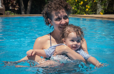 Fototapeta na wymiar View of Brazilian Mother and Daughter playing at the pool