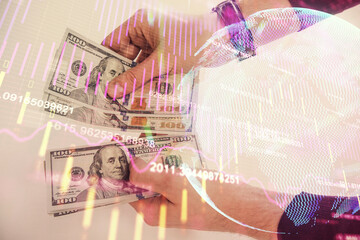 Multi exposure of financial graph drawing hologram and USA dollars bills and man hands. Analysis concept.