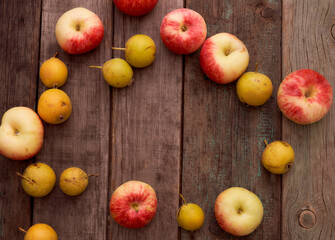 Red apples and small pear lie on a wooden board. Top view.With copy space.