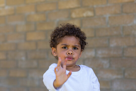 Child Frowning With Hand Up Signalling Stop