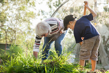 Grandson and granny gardening together in the backyard