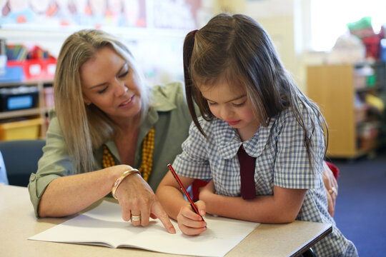 Female school teacher helping student with her work