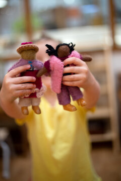 Child showing two felt dolls