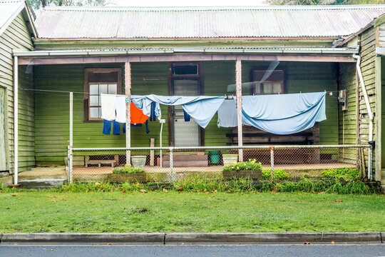 Washing hanging on a clothes line under the back verandah of a house
