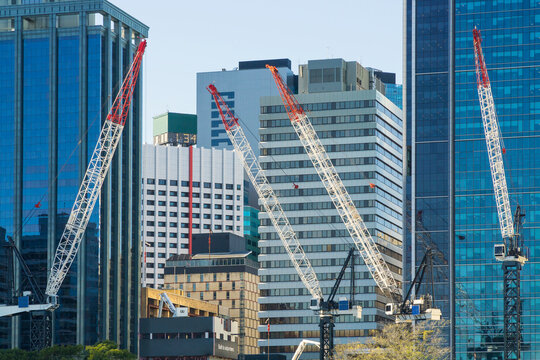 Construction cranes working amongst tall city buildings