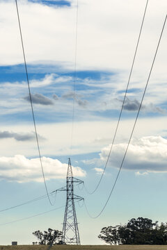 Electrical cables drooping through the air to a stanchion in the distance