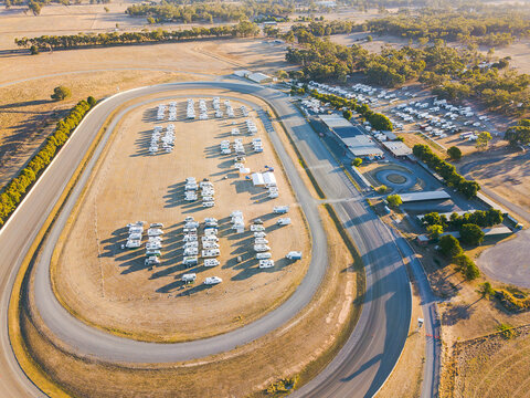Aerial view of dozens of motorhomes parked at a racetrack