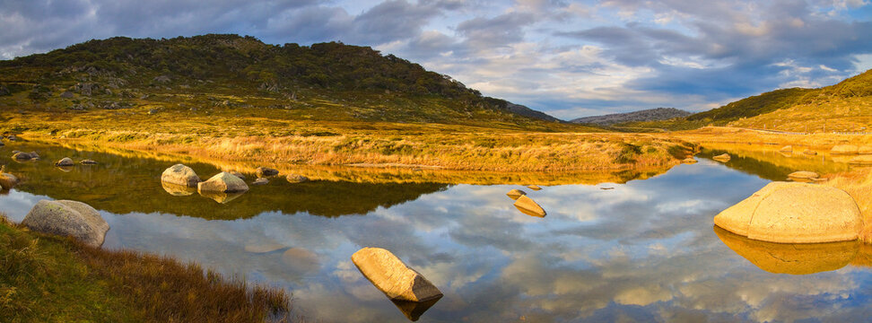 Reflections of a dramatic sky over a mountain stream