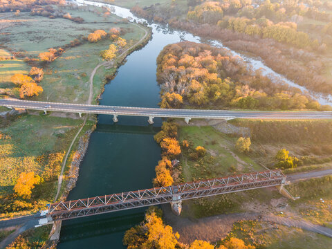 Aerial view of bridges spanning a river lined with Autumn trees