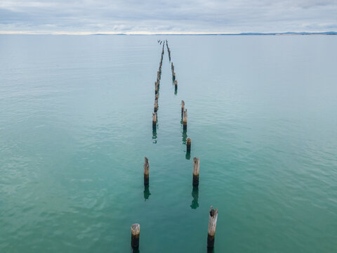 Looking down on a row of old jetty pylons disappearing toward the horizon