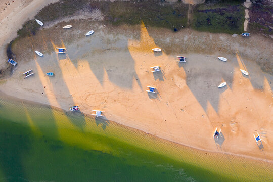 Aerial view of boats and catamarans pulled up onto a beach