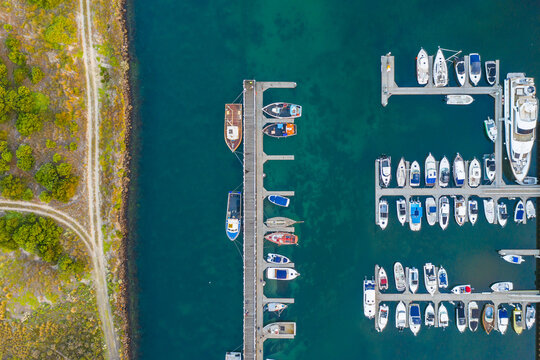 Aerial view of boats and yachts anchored along jettys at a marina